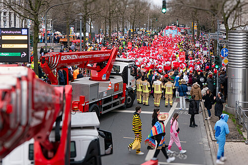 Rote_Jecken_treffen_auf_rote_Arbeitsbuehnen_beim_Rosenmontagszug